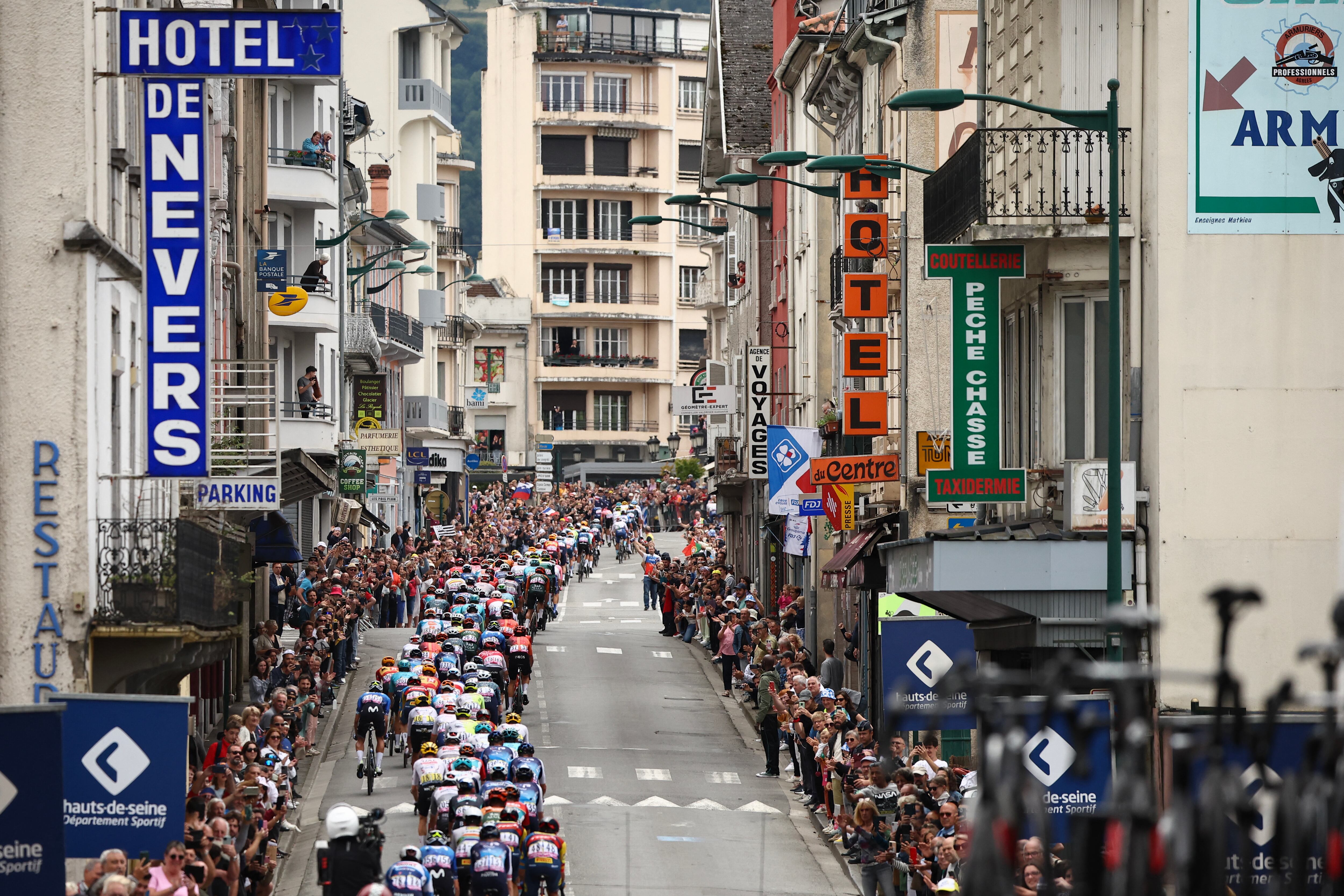 El pelotón recorre la ciudad de Lourdes durante la 14ª etapa de la 111ª edición del Tour de Francia, 151,9 km entre Pau y Saint-Lary-Soulan Pla d'Adet, en los Pirineos en el suroeste de Francia, el 13 de julio de 2024. (Foto de Anne-Christine POUJOULAT / AFP)