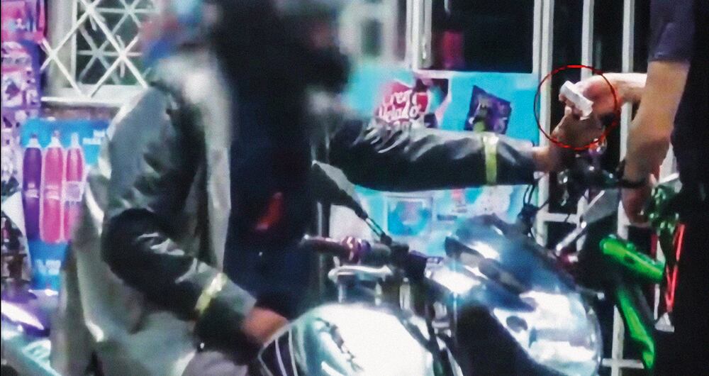    En la imagen se observa el momento exacto en el que el hombre de la bicicleta le paga a su dealer (motociclista) luego de haber recibido un paquete con una importante cantidad de marihuana, en plena vía pública de la capital del país.