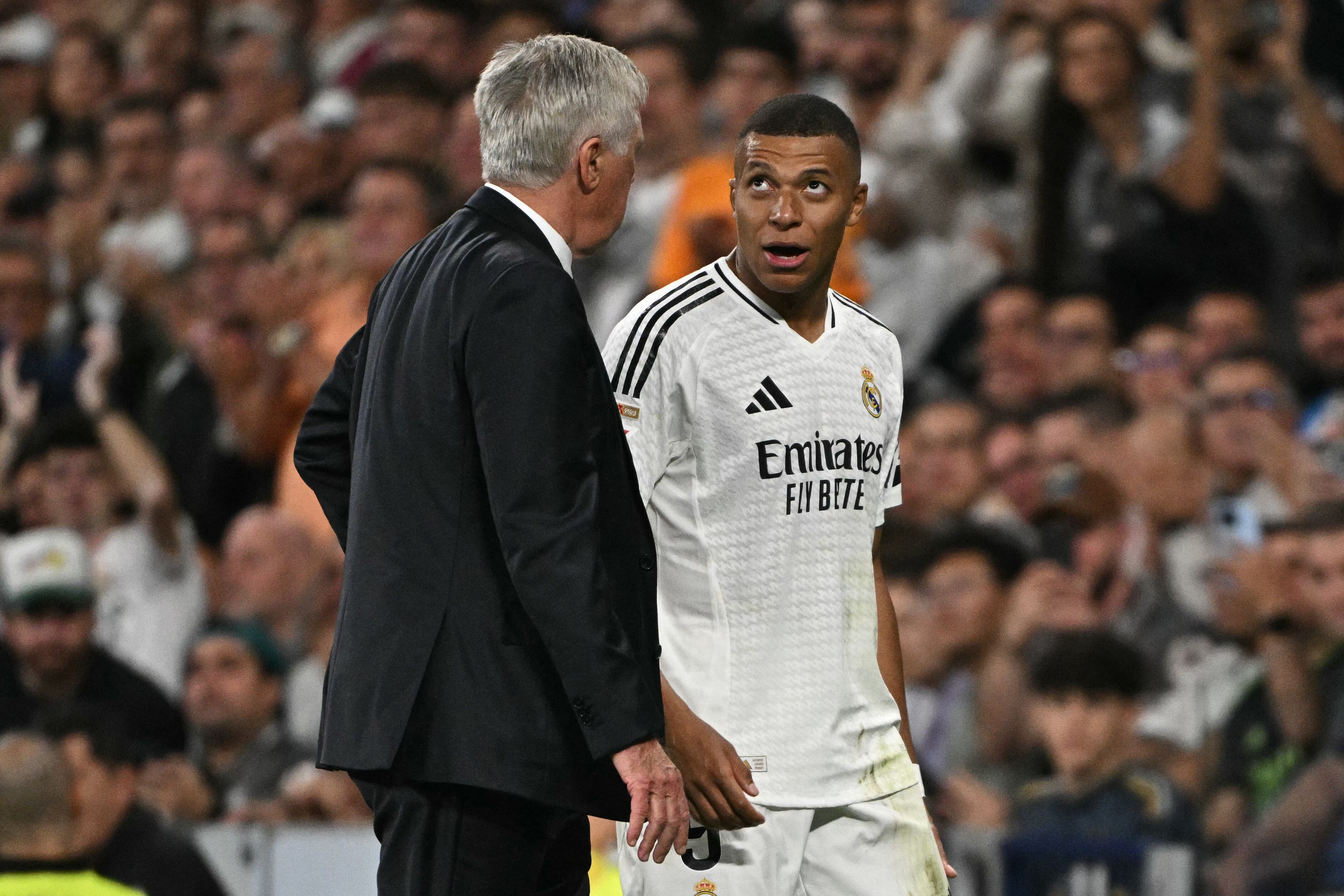 Real Madrid's French forward #09 Kylian Mbappe talks with Real Madrid's Italian coach Carlo Ancelotti as he leaves the pitch during the Spanish league football match between Real Madrid CF and Deportivo Alaves at the Santiago Bernabeu stadium in Madrid on September 24, 2024. (Photo by JAVIER SORIANO / AFP)