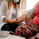 Joven médico visitando a su paciente senior en casa