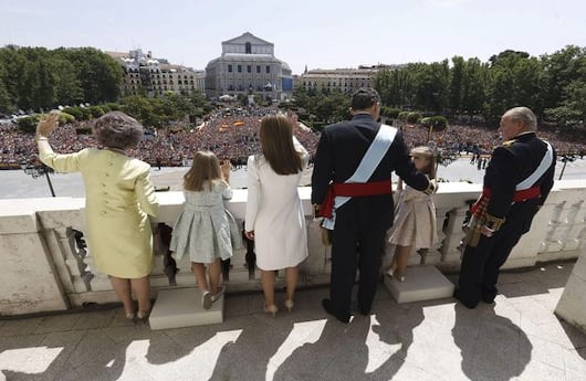 Los reyes, Felipe VI y Letizia, junto a sus hijas, Leonor, princesa de Asturias, y la infanta Sofía, y don Juan Carlos y doña Sofía, saludan desde el balcón central del Palacio de Oriente a los ciudadanos. (EFE)