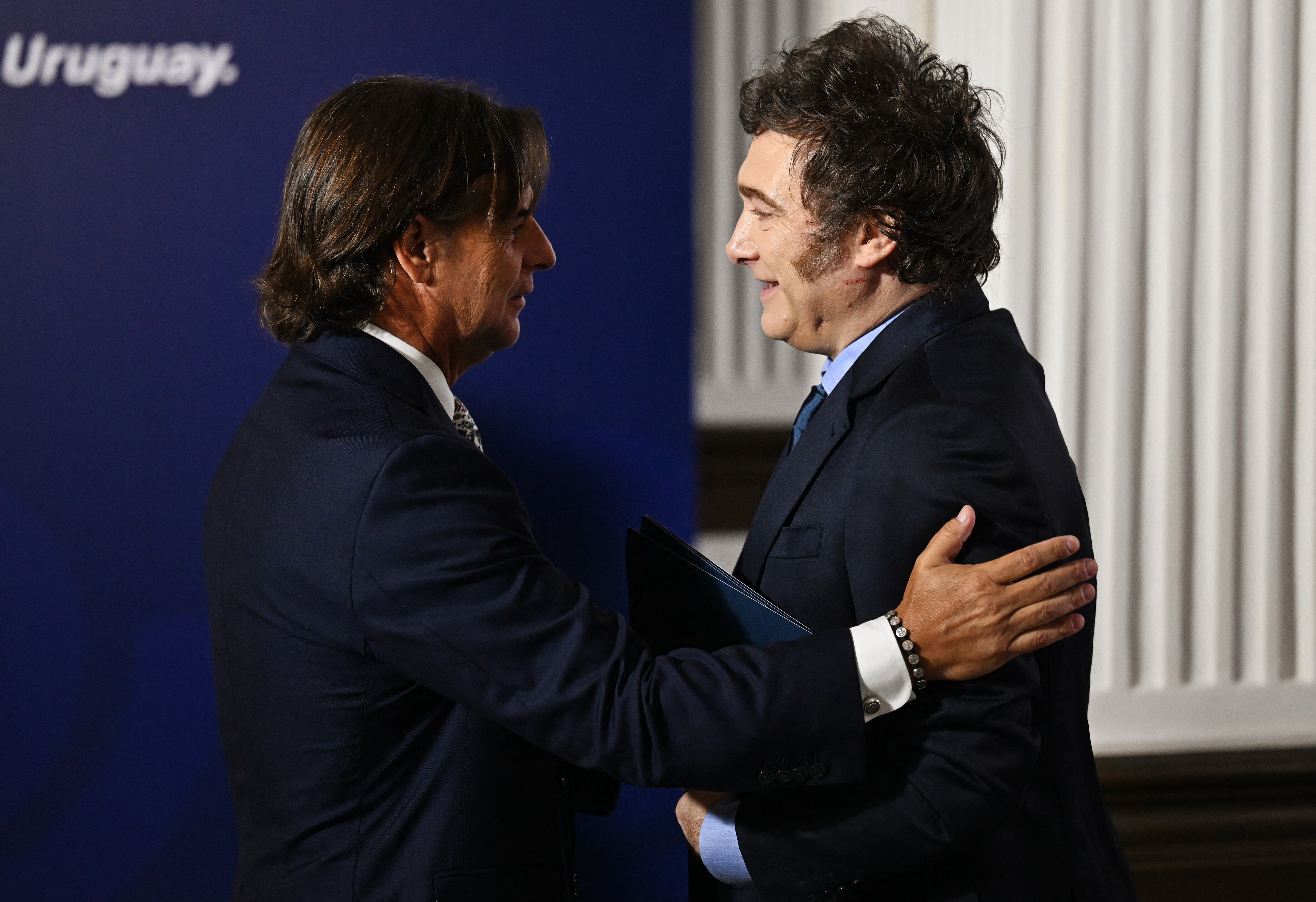 El presidente de Uruguay, Luis Lacalle Pou (izq.), da la bienvenida al presidente de Argentina, Javier Mieli, durante la LXV Cumbre del Mercosur en Montevideo el 6 de diciembre de 2024. (Foto de Eitan ABRAMOVICH / AFP)