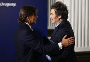 El presidente de Uruguay, Luis Lacalle Pou (izq.), da la bienvenida al presidente de Argentina, Javier Mieli, durante la LXV Cumbre del Mercosur en Montevideo el 6 de diciembre de 2024. (Foto de Eitan ABRAMOVICH / AFP)