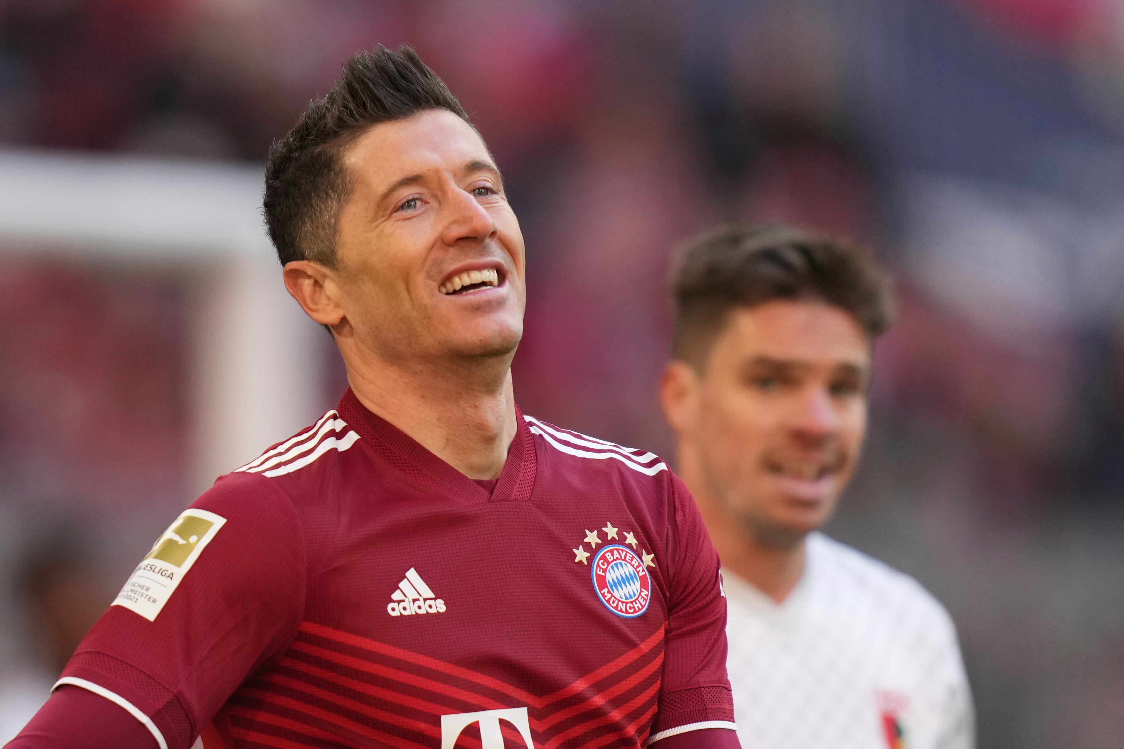 Bayern's Robert Lewandowski smiles after scoring the opening goal of the game from the penalty spot during the German Bundesliga soccer match between Bayern Munich and Augsburg at the Allianz Arena, in Munich Germany, Saturday, April 9, 2022. (AP Photo/Matthias Schrader )