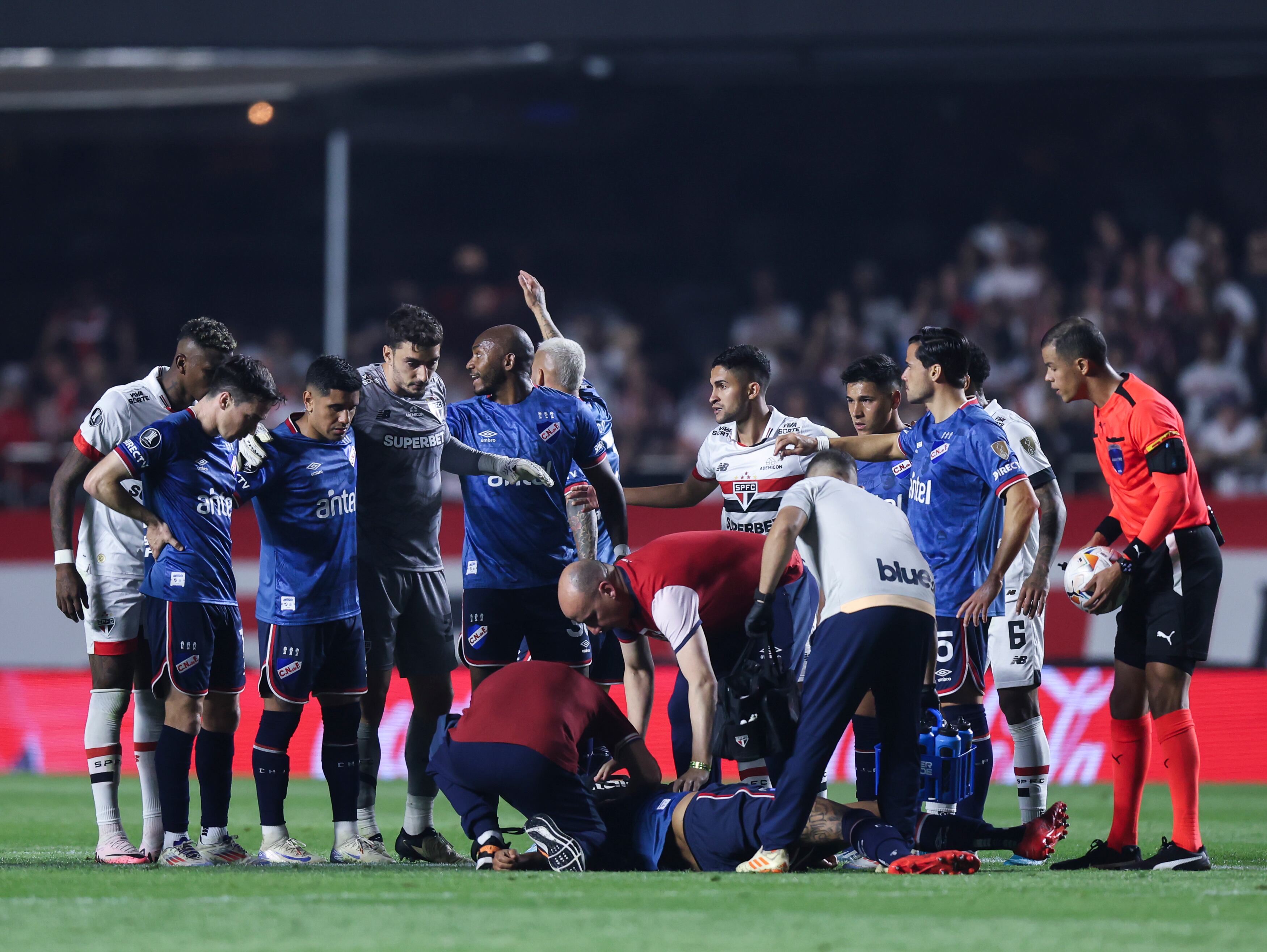 SAO PAULO, BRAZIL - AUGUST 22: Juan Izquierdo of Nacional received medical attention after fainting during a Copa CONMEBOL Libertadores 2024 Round of 16 second leg match between Sao Paulo and Nacional at MorumBIS on August 22, 2024 in Sao Paulo, Brazil.  (Photo by Alexandre Schneider/Getty Images)