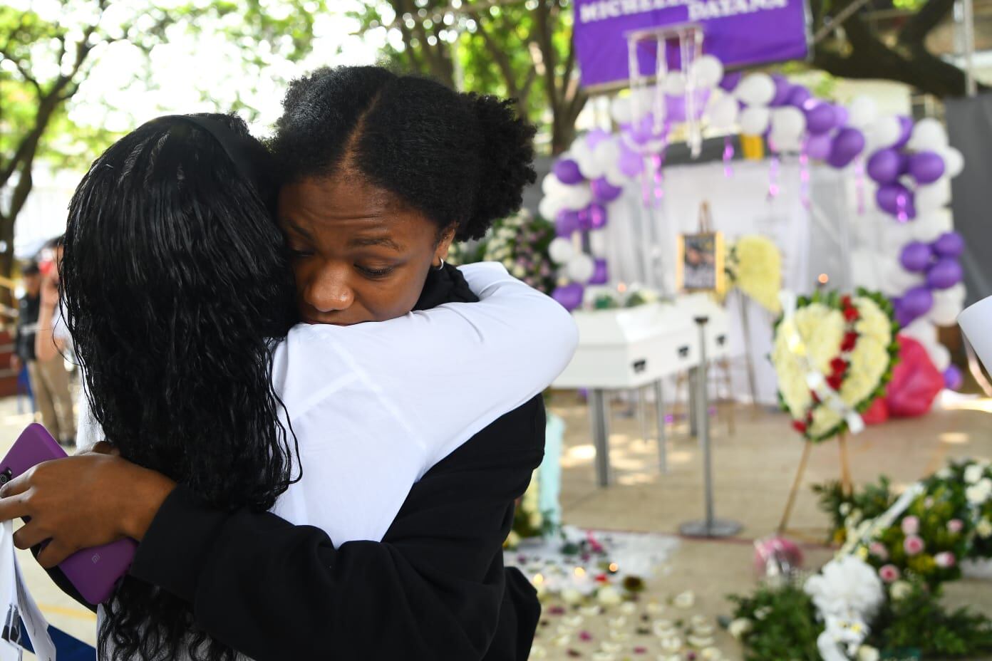 Las lágrimas, la incertidumbre y el dolor se apoderan de lugar. Seres queridos de Michel Dayana la despiden con flores, velas y oraciones.