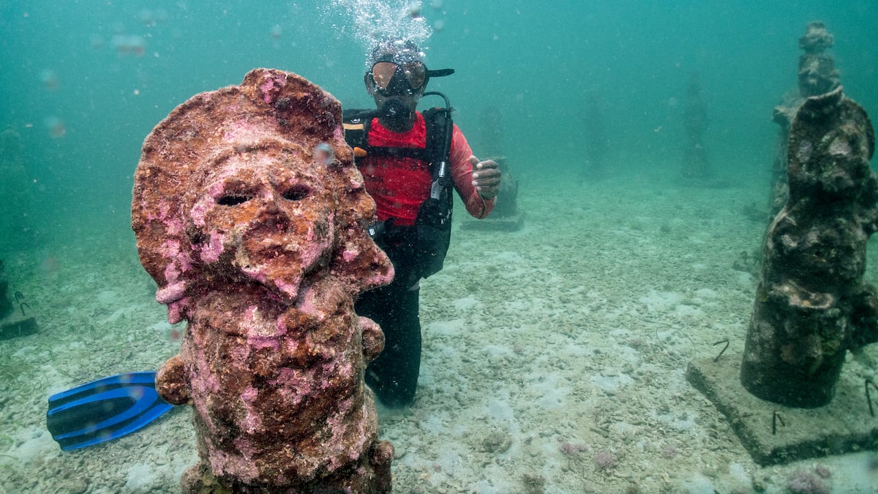 El guía Orlis Navas bucea en el MUSZIF underwater museum in Isla Fuerte, Bolivar department, Colombia, on May 22, 2024. In the Colombian Caribbean an underwater museum protects coral reefs threatened by tourism and climate change. (Photo by Luis ACOSTA / AFP)