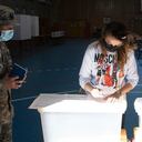 Una mujer instala mesas de votación en la escuela secundaria Portugal en Punta Arenas, Chile, el 20 de noviembre de 2021, en vísperas de las elecciones generales de Chile. - Siete candidatos participarán en las elecciones presidenciales de Chile, y las encuestas muestran dos claros favoritos en campos políticos opuestos: Gabriel Boric, de 35 años, de la alianza de izquierda Approve Dignity, que incluye al Partido Comunista, y el candidato de extrema derecha José Antonio Kast, de 55 años, del Partido Republicano. Partido: cada uno con aproximadamente una cuarta parte de la intención de voto declarada. (Foto de CLAUDIO REYES / AFP)