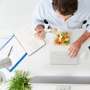 Vista aérea del empresario trabajando en equipo en la oficina comiendo el almuerzo