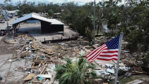 Una bandera estadounidense ondea sobre el Ayuntamiento destrozado el sábado 28 de septiembre de 2024 en Horseshoe Beach, Florida, tras el paso del huracán Helene. (AP Foto/Stephen Smith)