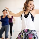 Instructor teaching dance to students at fitness club. Group of women dancing in a fitness dance studio.