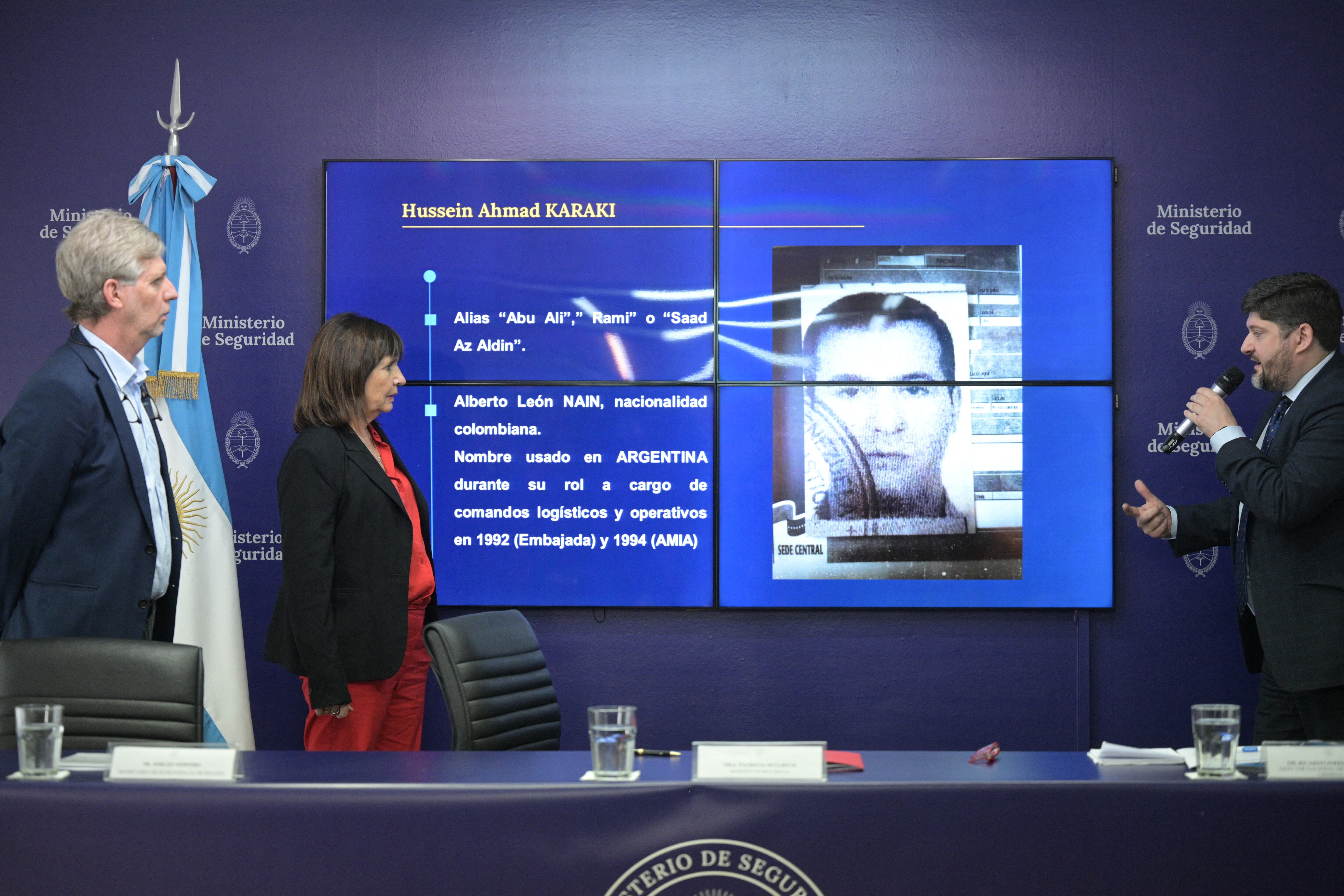 La Ministra de Seguridad de Argentina, Patricia Bullrich (centro), y el director del Secretario de Estado de Inteligencia (SIDE), Sergio Neiffert (i), escuchan al Director Nacional de Inteligencia Criminal, Ricardo Picado, mientras se dirige a la prensa frente a una pantalla que muestra la fotografía de Hussein Ahmad Karaki. acusado de ser el jefe de Hezbollah en Sudamérica y planificador de los atentados a la Embajada de Israel en 1992 y de la mutua judía AMIA en 1994, y para quien solicitaron una orden de arresto a Interpol, en Buenos Aires el 25 de octubre de 2024. Según Según un informe de la inteligencia argentina, Karaki se encontraba en Buenos Aires el día del ataque a la Embajada, el 17 de marzo de 1992, y había salido del país con pasaporte colombiano horas antes de la explosión. (Foto de JUAN MABROMATA/AFP)