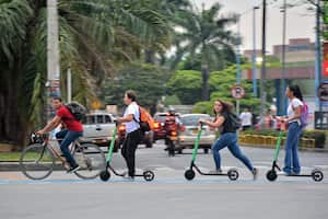 Varias jóvenes utlizan las patinetas eléctricas para llegar a la estación del MÍO Universidades en el sur de Cali. Diariamente se hacen 217.000 viajes en medios de transporte públicos y particulares que usan energía eléctrica. Foto: Jorge Orozco / El País