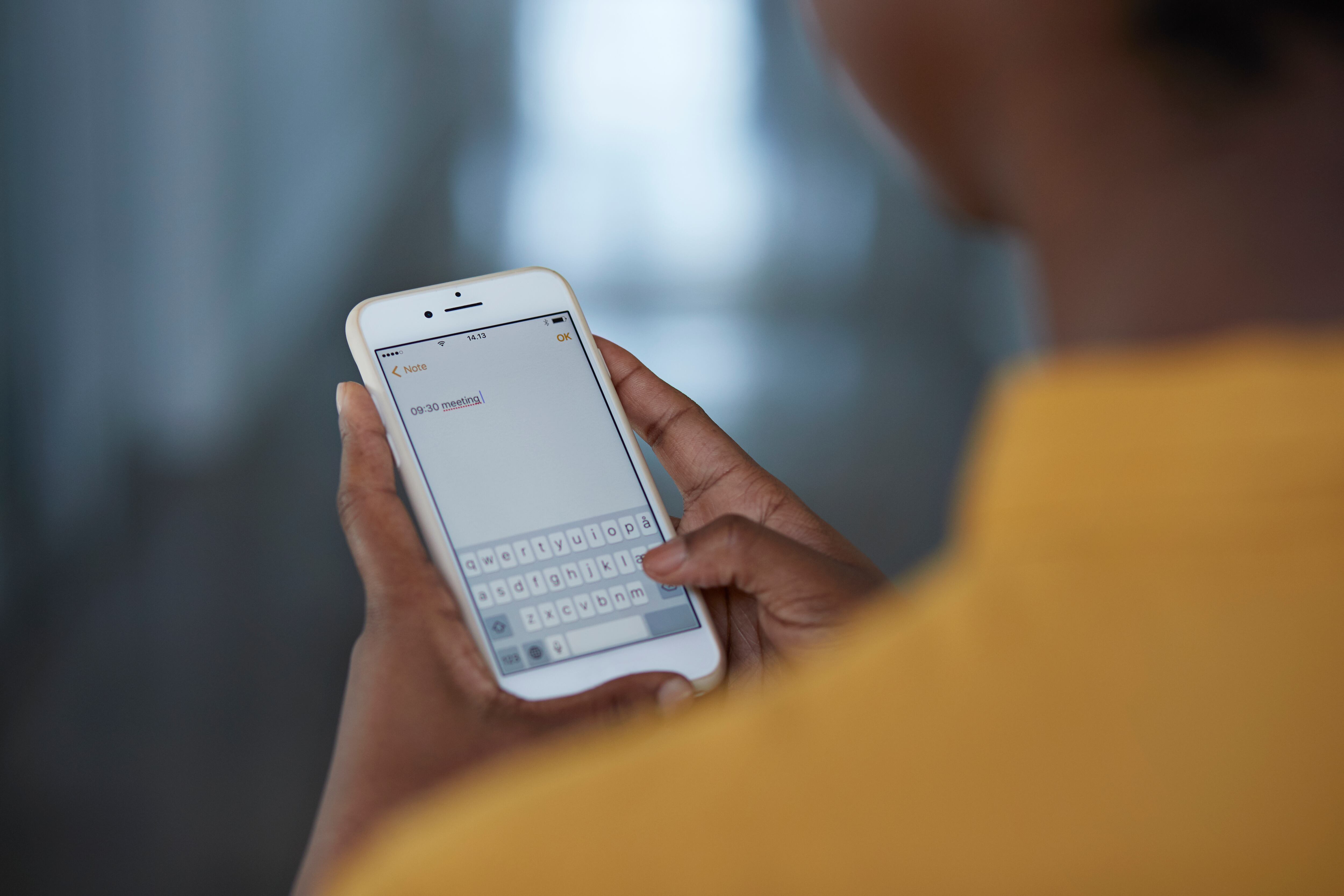 Persona enviando un mensaje desde su celular.