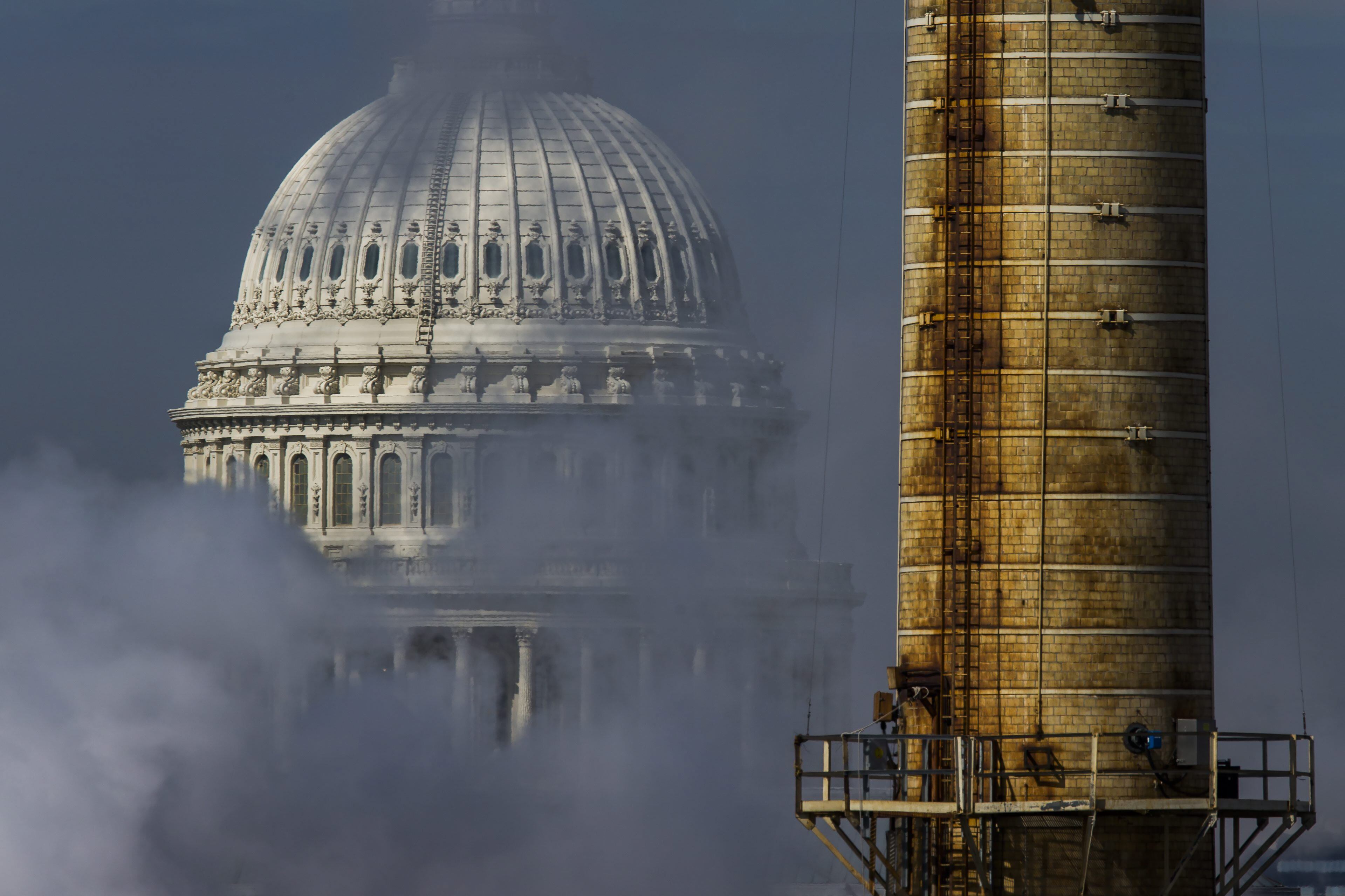 Vista del domo del Capitolio detrás de una chimenea de la Planta de Energía Capital, la única central eléctrica de carbón en la capital de Estados Unidos, en Washington.