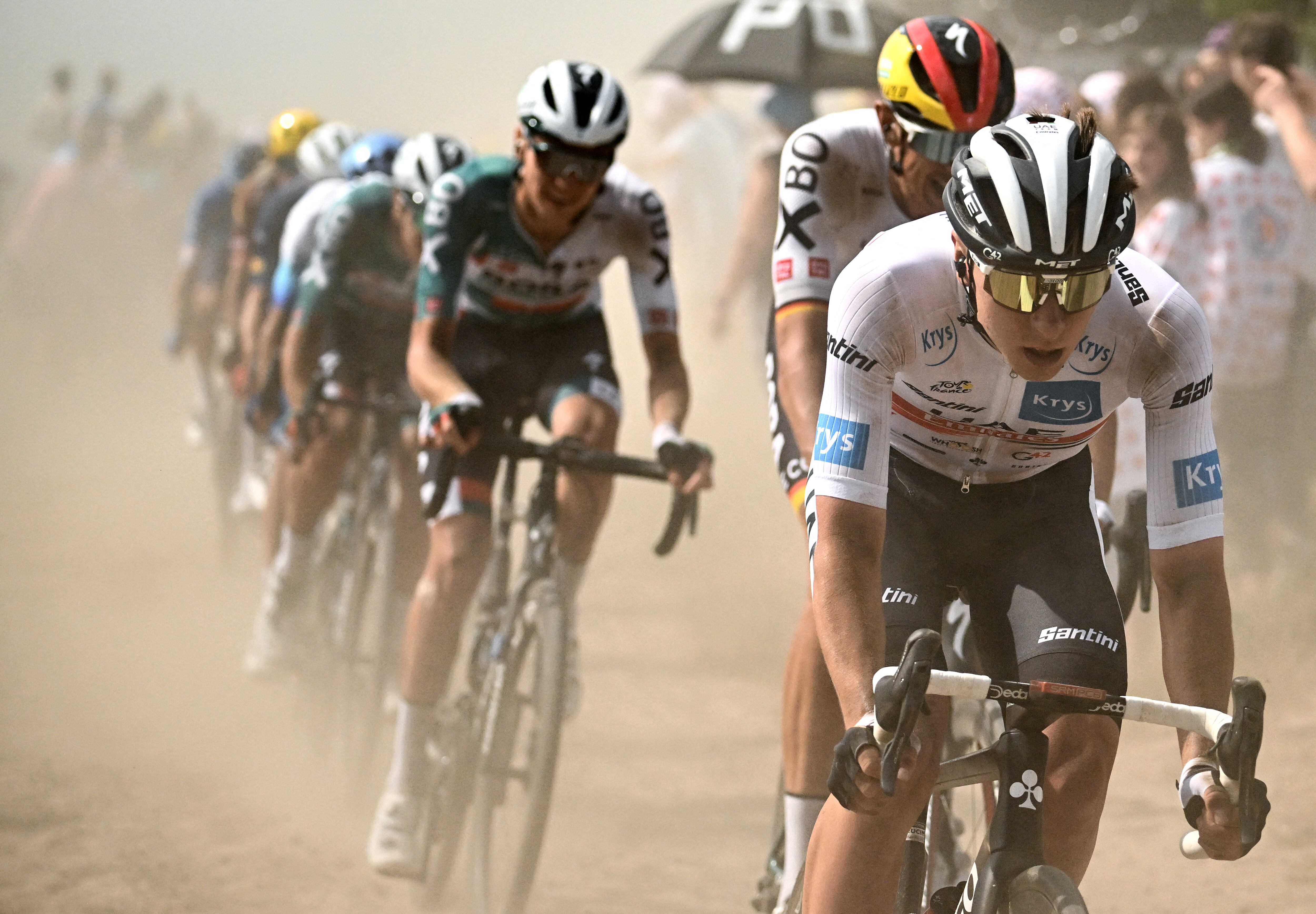 UAE Team Emirates team's Slovenian rider Tadej Pogacar wearing the best young rider's white jersey (R) cycles across a cobblestone sector with the pack of riders during the 5th stage of the 109th edition of the Tour de France cycling race, 153,7 km between Lille and Arenberg Porte du Hainaut, in northern France, on July 6, 2022. (Photo by Marco BERTORELLO / AFP)