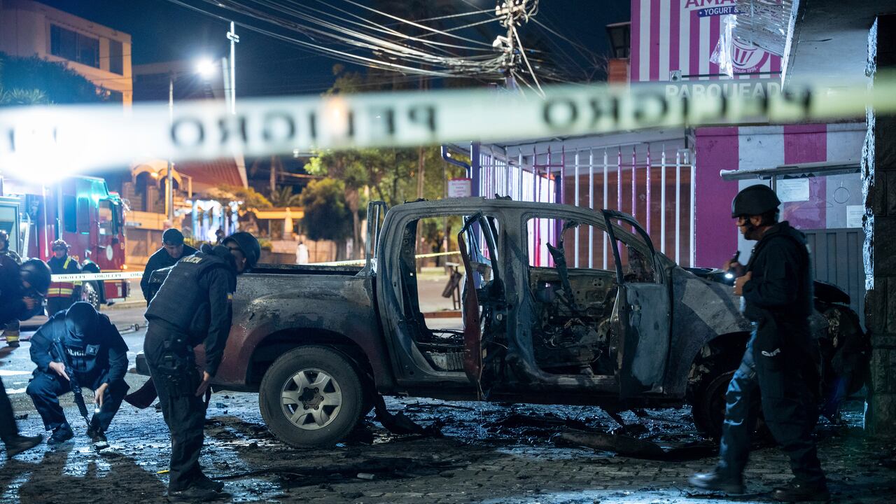 La policía inspecciona una camioneta que explotó afuera de una oficina utilizada por el Servicio Nacional de Atención a Personas Privadas de Libertad que administra el sistema penitenciario en Quito, Ecuador, la madrugada del jueves 31 de agosto de 2023. (AP Foto/Carlos Noriega)