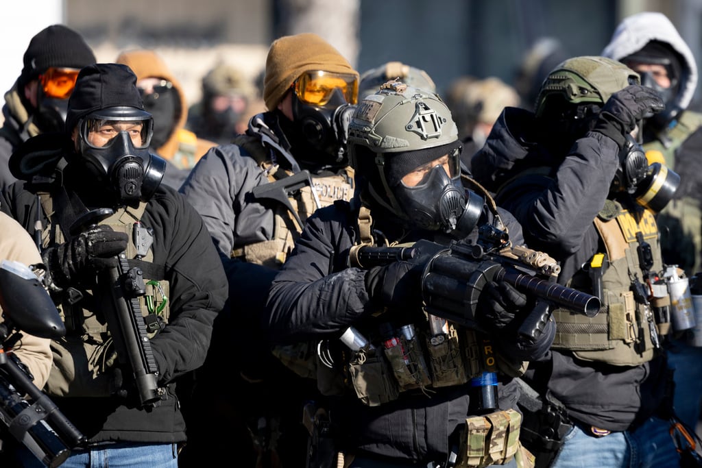 Agentes federales apuntan con sus armas a manifestantes cerca del lugar donde agentes federales mataron a tiros a Alex Pretti, de 37 años, en Minneapolis el sábado 24 de enero de 2026. (Ellen Schmidt/MinnPost vía AP)