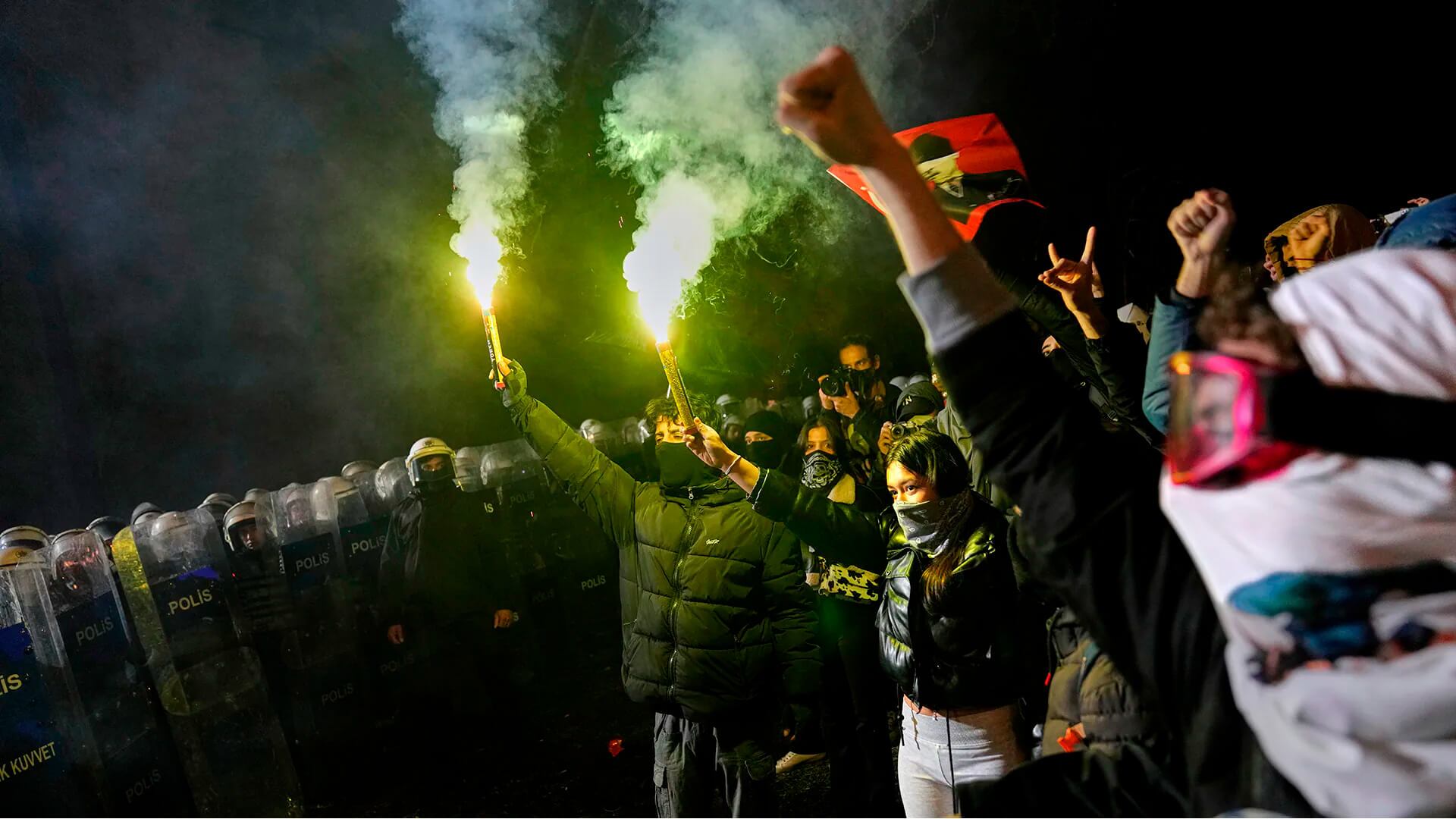La gente grita consignas junto a agentes de la Policía Antidisturbios durante una protesta en Turquía, después de que el alcalde de Estambul, Ekrem Imamoglu