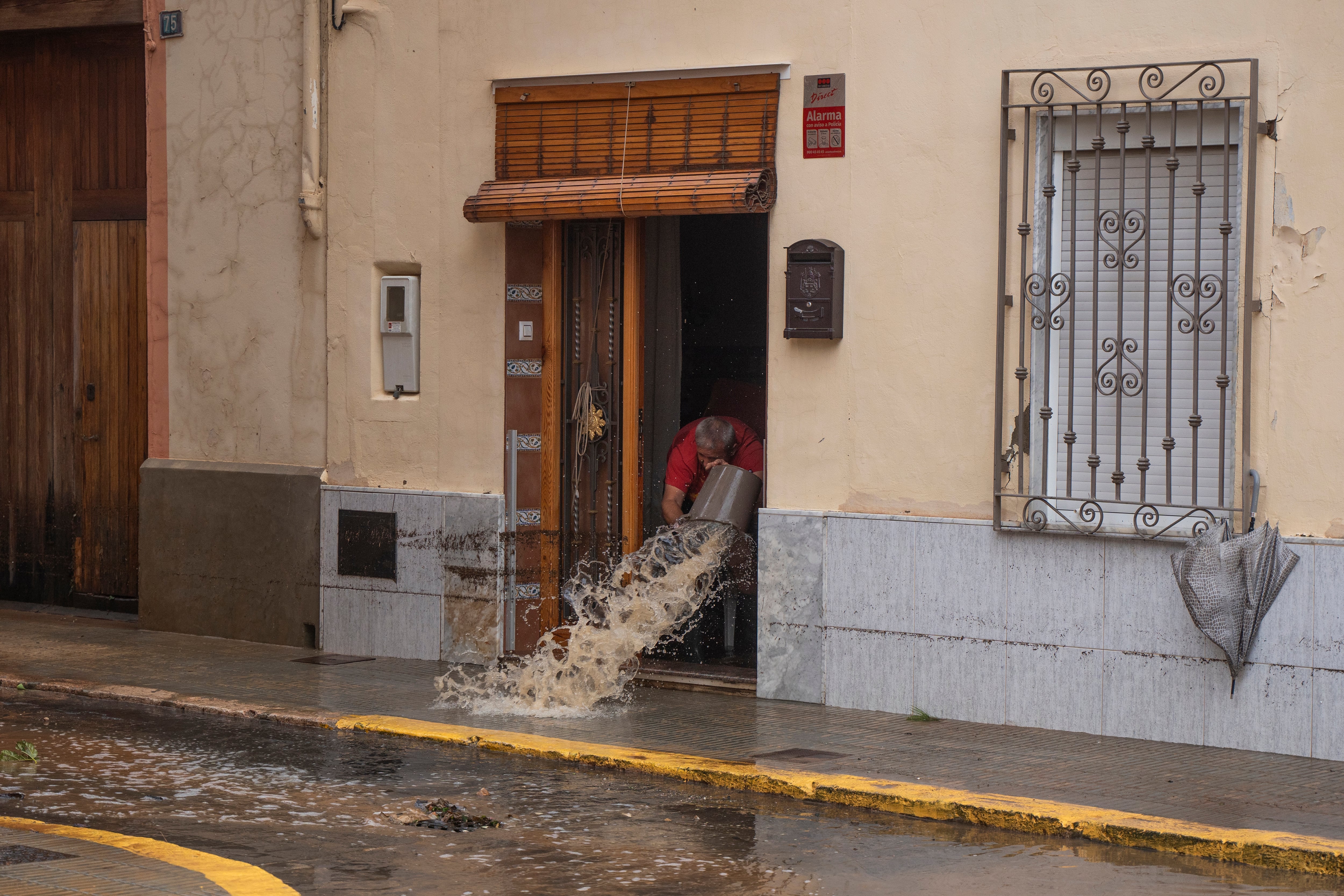 Un hombre arroja agua desde su casa después de las inundaciones en Valencia, España, el martes 29 de octubre de 2024. (Jorge Gil/Europa Press vía AP)