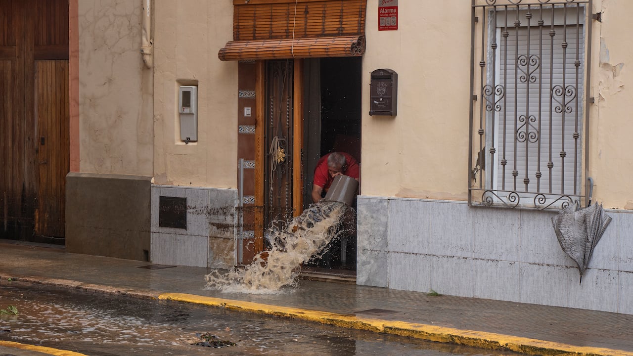 Un hombre arroja agua desde su casa después de las inundaciones en Valencia, España, el martes 29 de octubre de 2024. (Jorge Gil/Europa Press vía AP)