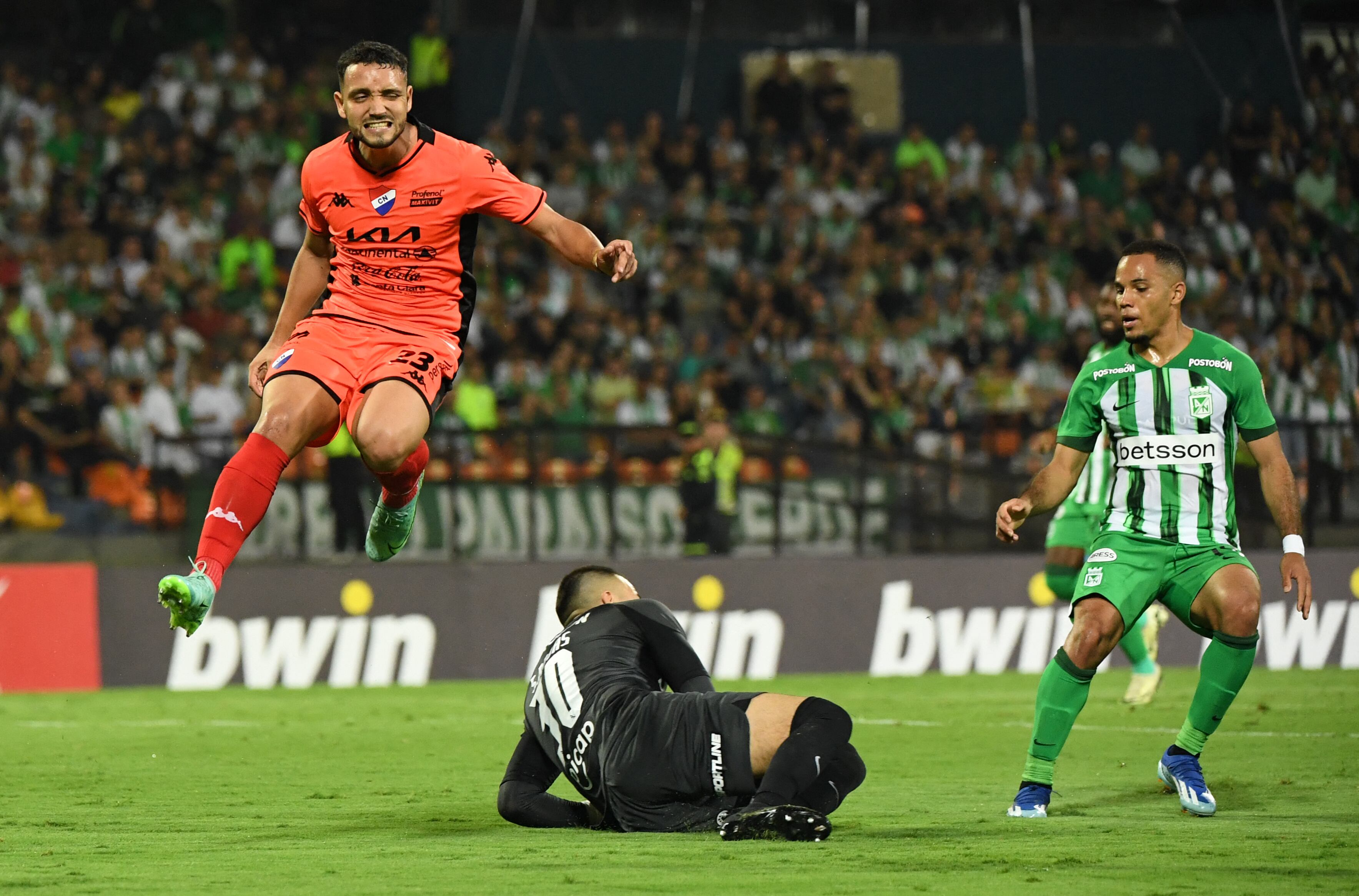 El portero del Atlético Nacional, Santiago Rojas (C) y el jugador del Nacional, Diego Duarte (L), luchan por el balón durante el partido de vuelta de la segunda ronda de la Copa Libertadores entre el Atlético Nacional de Colombia y el Nacional de Paraguay en el estadio Atanasio Girardot en Medellín, Colombia, en febrero. 28 de diciembre de 2024. (Foto de Jaime SALDARRIAGA / AFP)