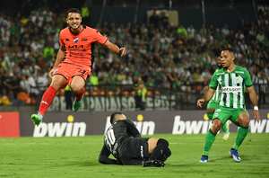 El portero del Atlético Nacional, Santiago Rojas (C) y el jugador del Nacional, Diego Duarte (L), luchan por el balón durante el partido de vuelta de la segunda ronda de la Copa Libertadores entre el Atlético Nacional de Colombia y el Nacional de Paraguay en el estadio Atanasio Girardot en Medellín, Colombia, en febrero. 28 de diciembre de 2024. (Foto de Jaime SALDARRIAGA / AFP)
