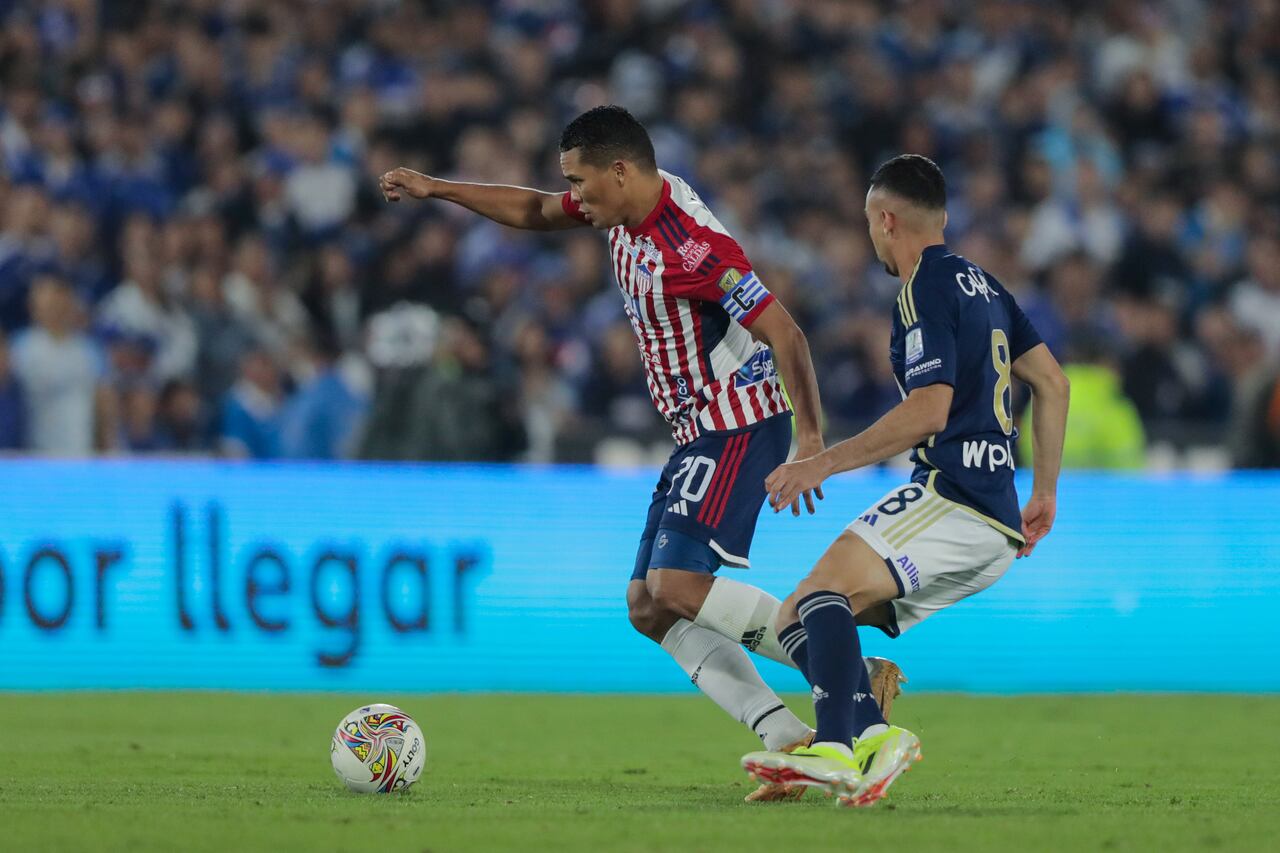 BOGOTA, COLOMBIA - APRIL 17: Carlos Bacca of Junior de Barranquilla competes for the ball with Daniel Giraldo of Millonarios F.C during a 17th round match between Millonarios F.C and Junior de Barranquilla as part of Primera A tournament at Estadio El Campin on April 17, 2024 in Bogota, Colombia. (Photo by Andres Rot/Getty Images)