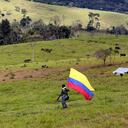 Un hombre camina con la bandera de Colombia al finalizar la ceremonia de dejación de armas.
