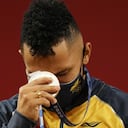 El colombiano Luis Mosquera celebra en el podio tras ganar la medalla de plata en los 67 kilogramos del levantamiento de pesas de los Juegos Olímpicos de Tokio, el domingo 25 de julio de 2021. (AP Foto/Luca Bruno)
