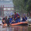 Los equipos de rescate recorren un vecindario donde fuertes lluvias han causado graves daños en la capital china.