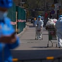 Guardias de seguridad con equipo de protección transfieren bienes a edificios residenciales con barricadas cerrados para el control de la salud luego de un caso de COVID-19 detectado en el área, el lunes 28 de marzo de 2022, en Beijing. Foto AP/Andy Wong) Lectura de la enfermedad por coronavirus (COVID-19) en Shanghái, China, 28 de marzo de 2022. REUTERS/Aly Song/Foto de archivo