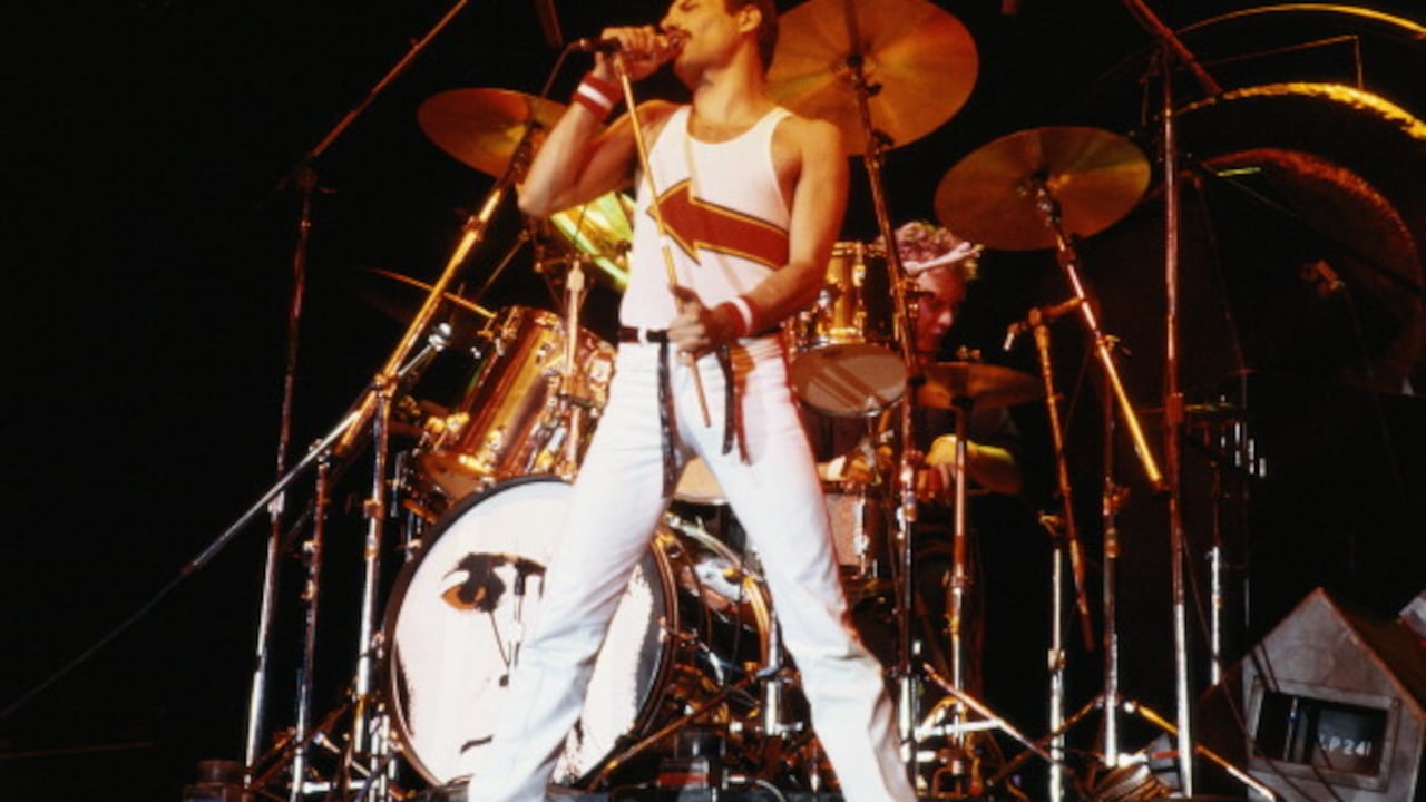 Freddie Mercury (1946-1991), cantante de Queen, de pie frente a una batería mientras canta frente a un micrófono en el escenario durante un concierto en vivo de la banda en el National Bowl de Milton Keynes, Inglaterra, Reino Unido, el 5 de junio. 1982. (Foto de Fox Photos/Hulton Archive/Getty Images)