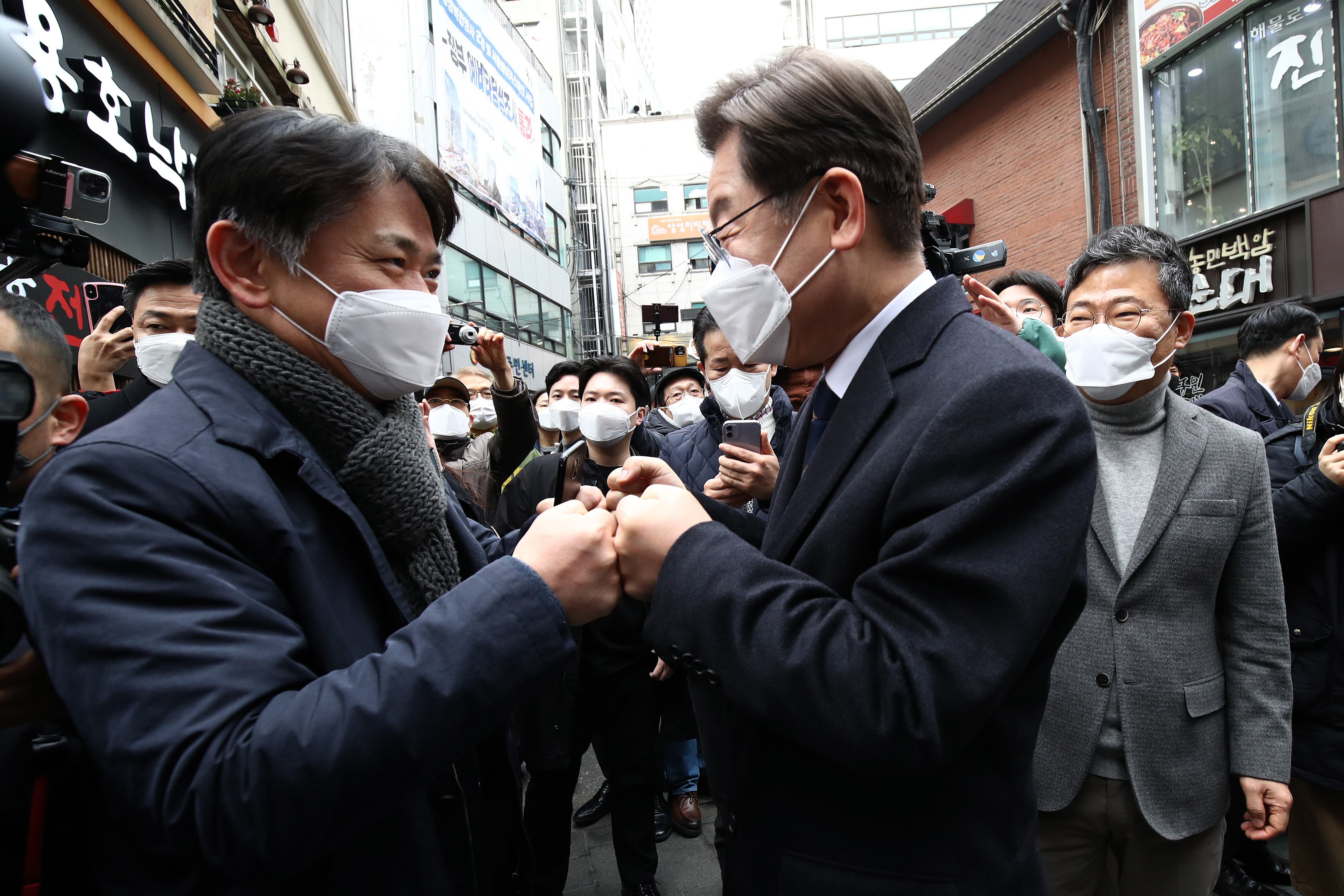 SEOUL, SOUTH KOREA - MARCH 04: Lee Jae-myung (R) the presidential candidate of the ruling Democratic Party cheers with a man after casting his preliminary vote for March 9 presidential election at a local polling station on March 04, 2022 in Seoul, South Korea. On March 9, South Koreans will elect their next president. The two front-runners, Lee Jae-myung of the Democratic Party and Yoon Suk-yeol of the People Power Party, are locked in a tight contest. (Photo by Chung Sung-Jun/Getty Images)
