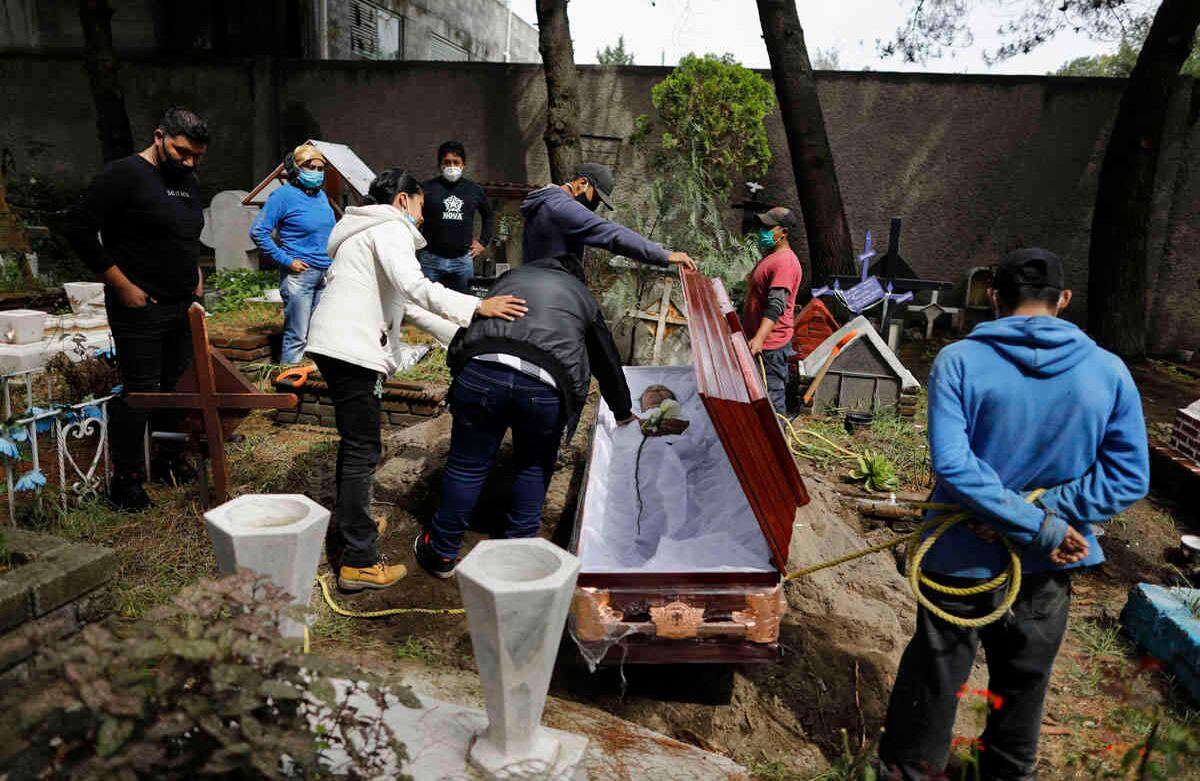 Los familiares de un hombre de 63 años que murió de un ataque al corazón se despiden de él en el cementerio de Xilotepec en Xochimilco, Ciudad de México. La familia dijo que la muerte no estaba relacionada con el coronavirus. Imagen del 27 de julio. Foto: Rebecca Blackwell / AP