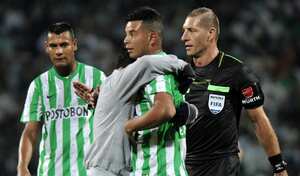 Edwin Cardona recibe el abrazo de un hincha en plena cancha mientras jugaba con Nacional.