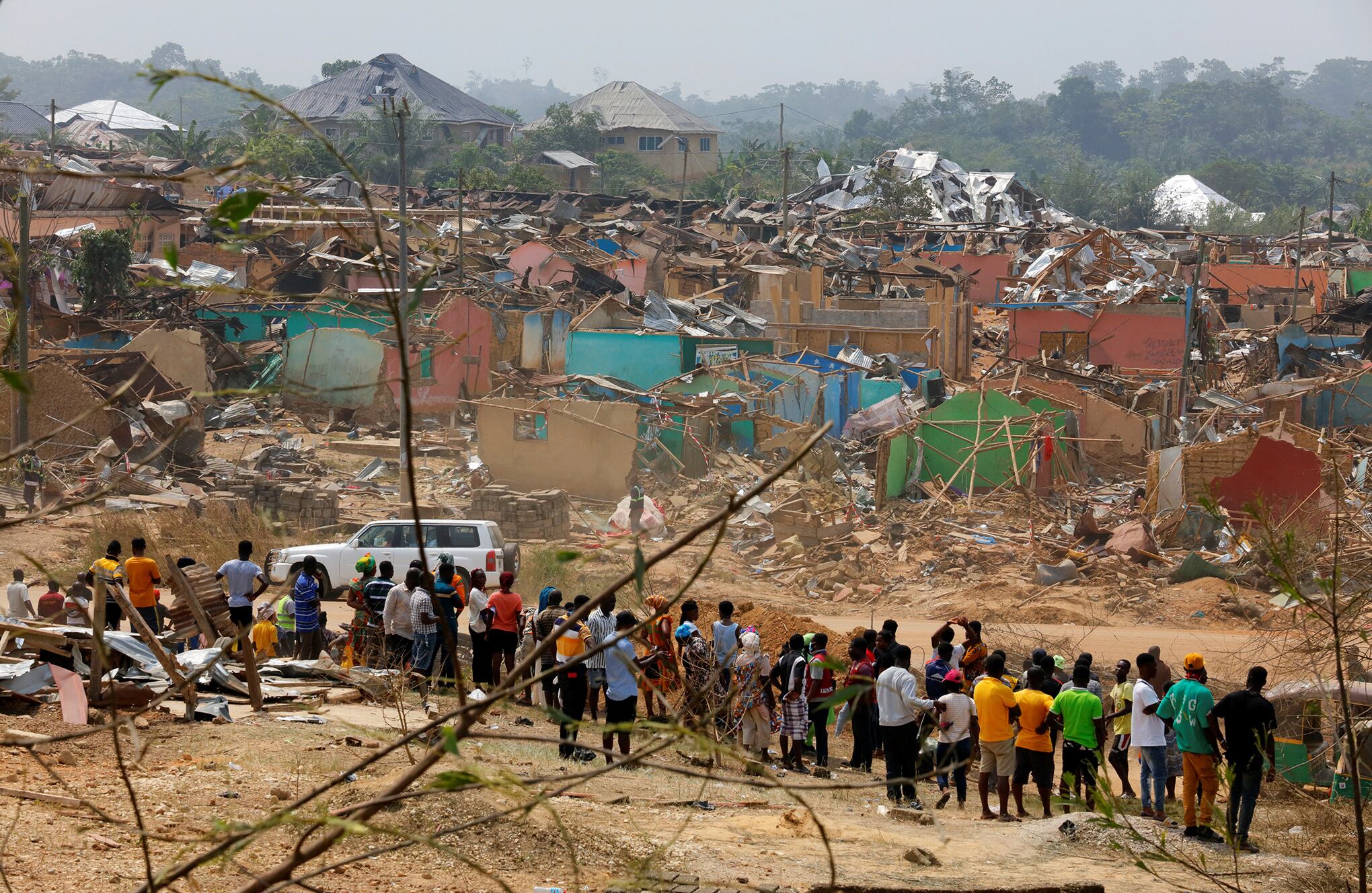 La gente observa los daños causados cuando un vehículo que transportaba explosivos mineros detonó a lo largo de una carretera en Apiate, Ghana. Foto REUTERS/Francis Kokoroko