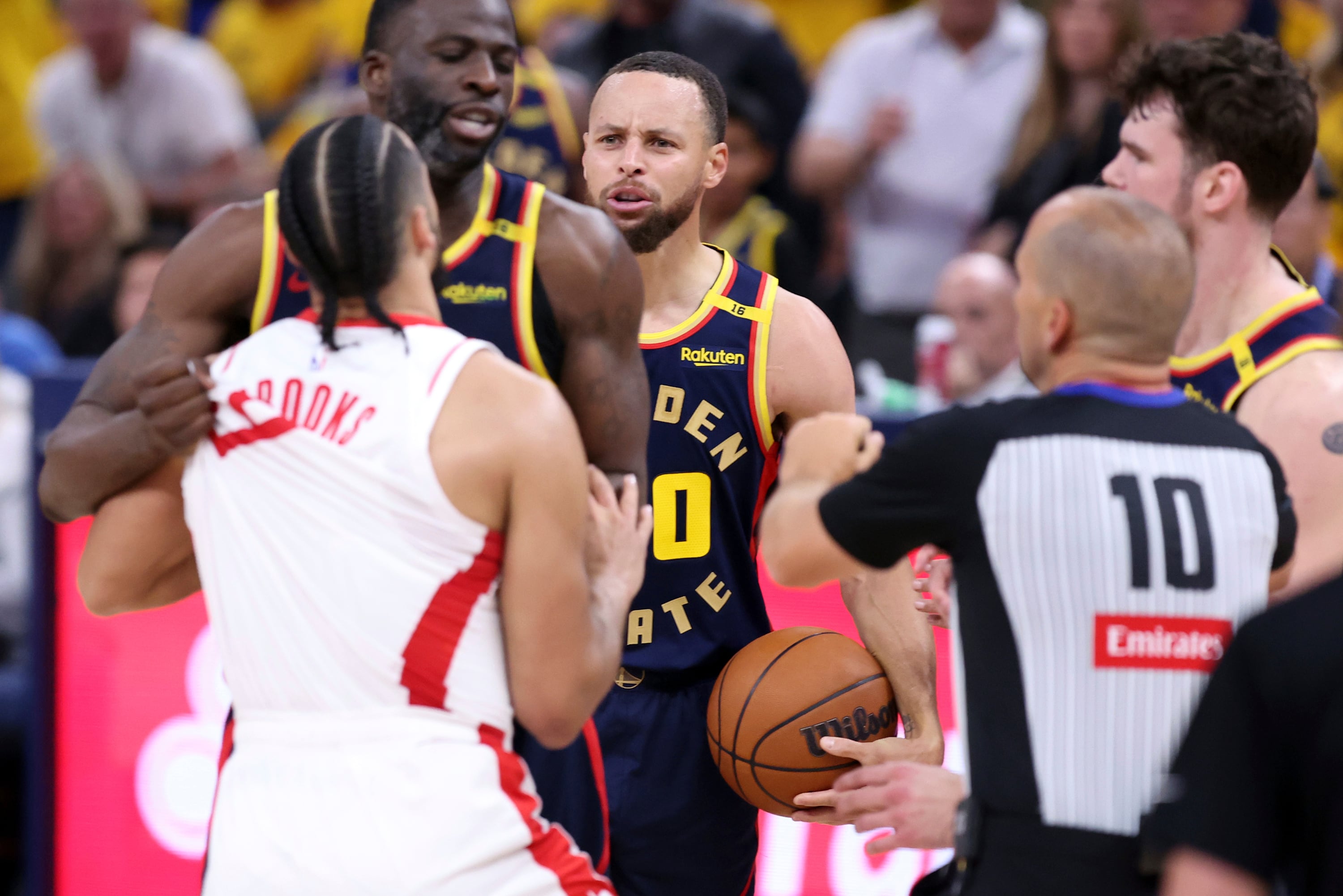 Golden State Warriors' Stephen Curry, center, watches Draymond Green scuffle with Houston Rockets' Dillon Brooks in the second quarter of an NBA Playoffs' First Round Game 4 at Chase Center in San Francisco on Monday, April 28, 2025.(Scott Strazzante/San Francisco Chronicle via AP)