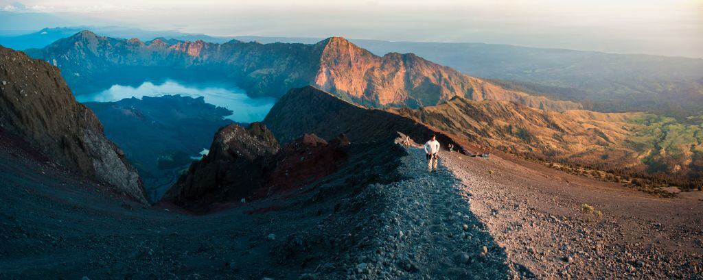 Foto panorámica de un turista hacia la cumbre de 3726 m del Monte Rinjani al amanecer, Indonesia, Asia
