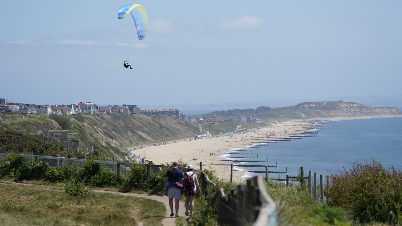 Heat haze softens the scene as a paraglider takes to the sky over the cliffs above Boscombe beach in Dorset. Temperatures are warming up for the weekend as most of Britain can expect to be bathed in sunshine. However, the Met Office warned that a sun-kissed Saturday, which would be ideal for a barbecue, could be followed by heavy rain and thunderstorms. Picture date: Saturday May 14, 2022. (Photo by Andrew Matthews/PA Images via Getty Images)