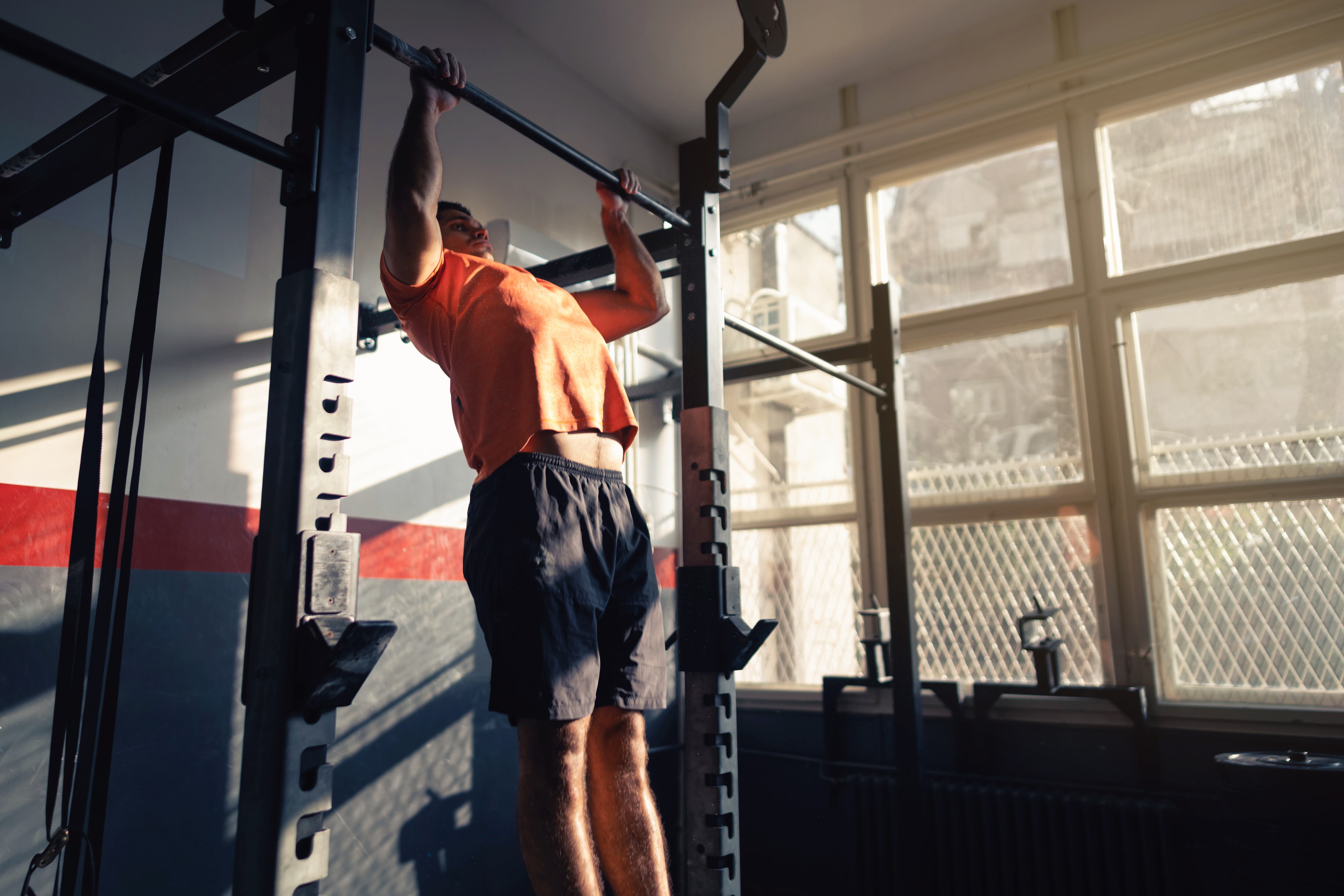 Hombre en el gimnasio realizando un muscle up