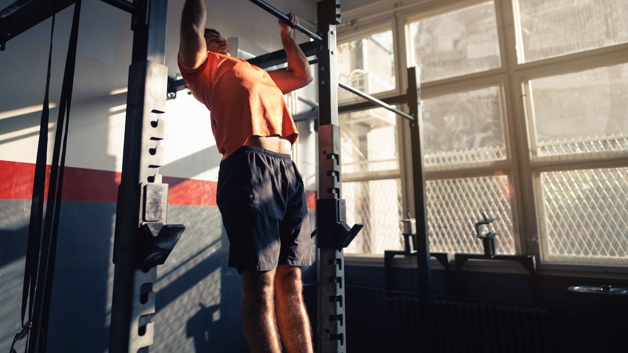 Hombre en el gimnasio realizando un muscle up