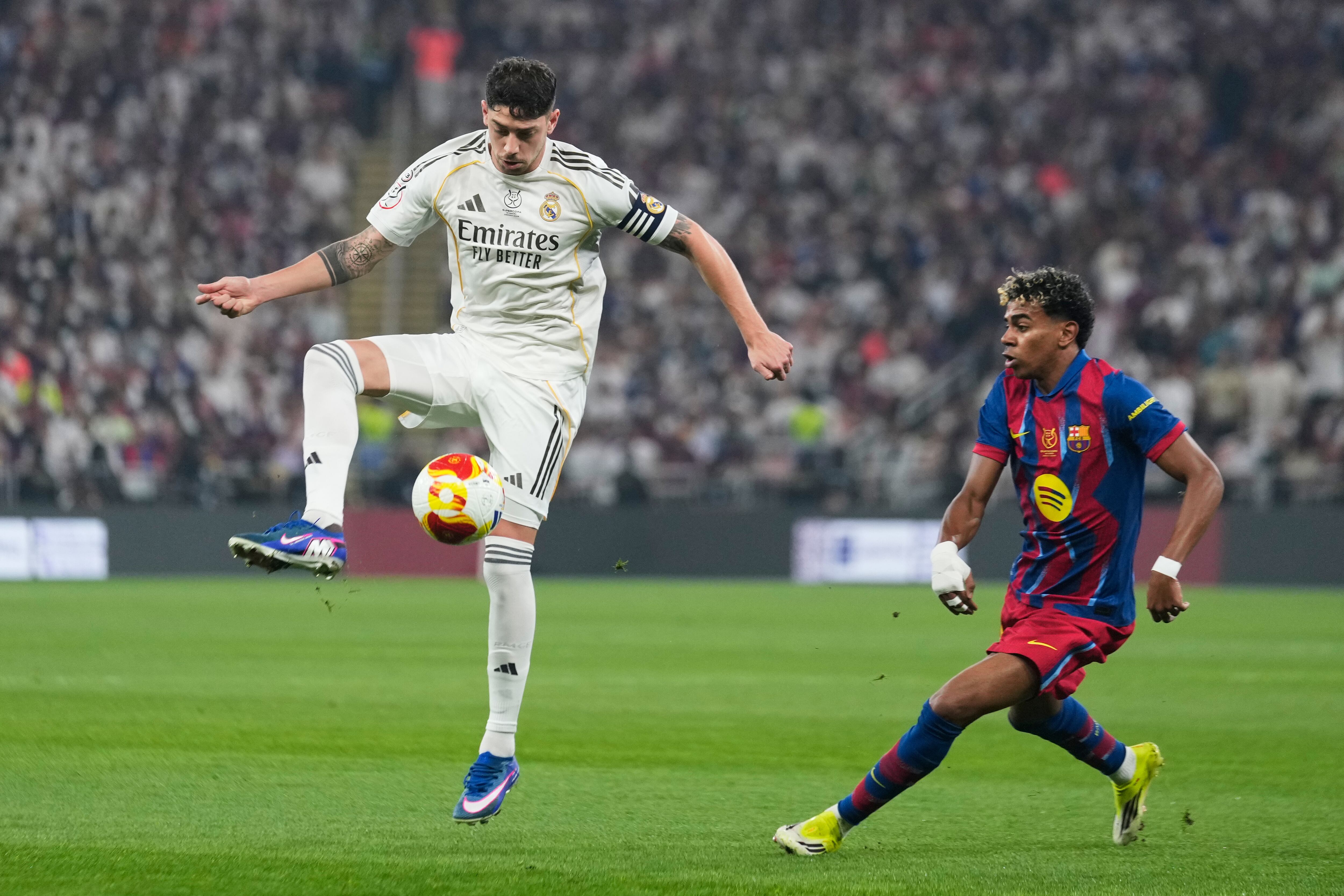 Real Madrid's Federico Valverde, left, controls the ball next to Barcelona's Lamine Yamal during the Spanish Super Cup final soccer match at King Abdullah Sports City Stadium in Jeddah, Saudi Arabia, Sunday, Jan. 11, 2026. (AP Photo/Altaf Qadri)