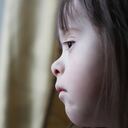 Niña con síndrome de down triste.