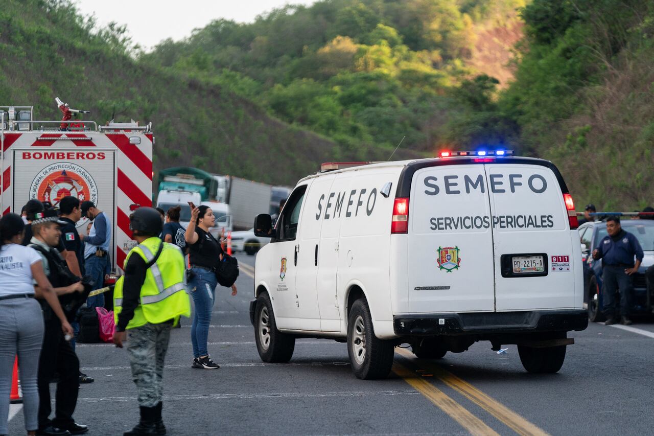 Vehículo del servicio forense llega al sitio donde un autobús que viajaba hacia Tijuana se estrelló en una carretera, matando a varias personas