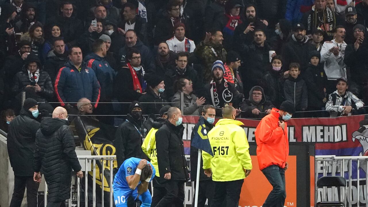 Dimitri Payet del Marsella cae al suelo tras ser agredido por un proyectil lanzado desde la grada durante el partido contra Lyon por la liga francesa