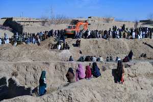 Los afganos reunidos mientras los rescatistas intentaban alcanzar y rescatar al niño.