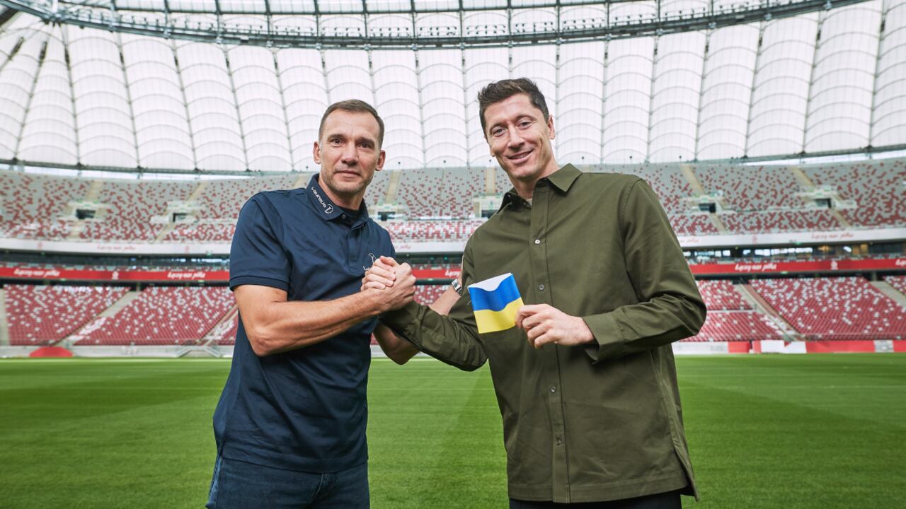 WARSAW, POLAND - SEPTEMBER 20: Poland captain Robert Lewandowski receives a Ukraine armband from Laureus Ambassador Andriy Shevchenko and pledges to carry it to FIFA World Cup 2022 Qatar at PGE Narodowy Stadium on September 20, 2022 in Warsaw, Poland. (Photo by Joosep Martinson/Getty Images for Laureus)