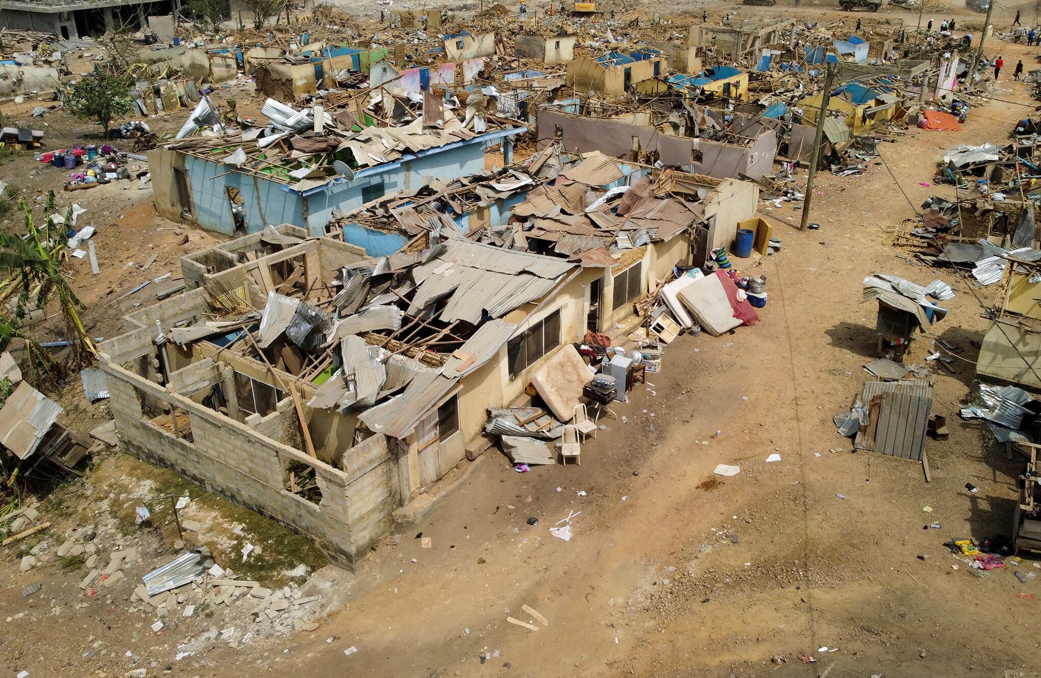 La gente observa los daños causados cuando un vehículo que transportaba explosivos mineros detonó a lo largo de una carretera en Apiate, Ghana. Foto REUTERS/Francis Kokoroko