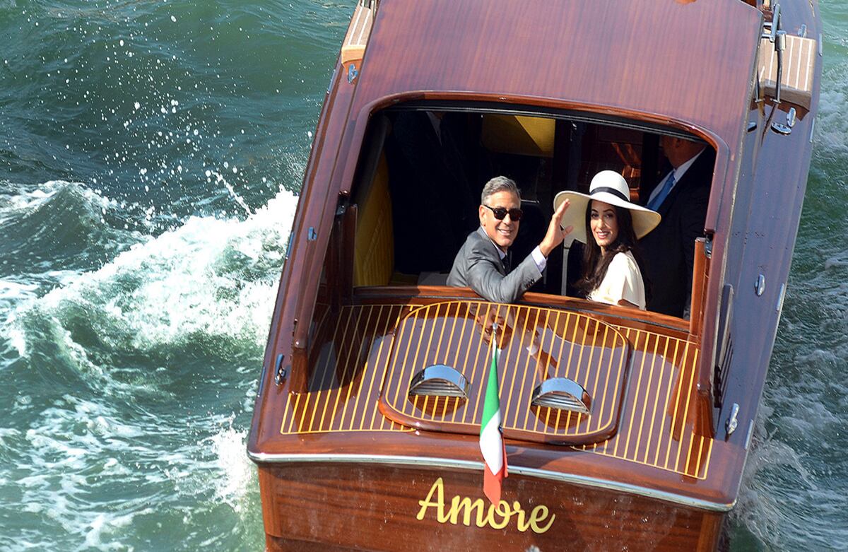 Luego de casarse en el ayuntamiento local, George Clooney saluda junto a su esposa Amala Alamuddin mientras se aleja de la ciudad de Venecia. (AP)